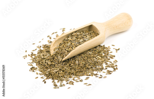 Heap dill seed on the spoon, isolated on white background. Close-up