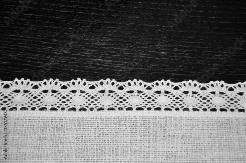 Beautiful black and white lacy lace white embroidery linen textile on wooden desk background