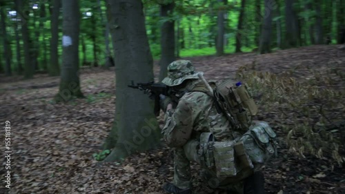 Guerilla partisan warrior aiming in forest ambush carrying his gun. Partisan war reconstruction. War battlefield maneuvers training.