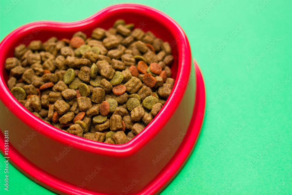 Red bowl full of multicolored dog food Red bowl full of multicolored dog food