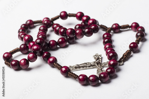 Rosary and a cross on a light gray background. 