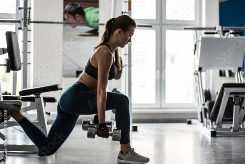 Female sportsman with a stunning figure working out in gym. A female fitness instructor doing exercises. Fitness club gym training lifestyle commercial concept.