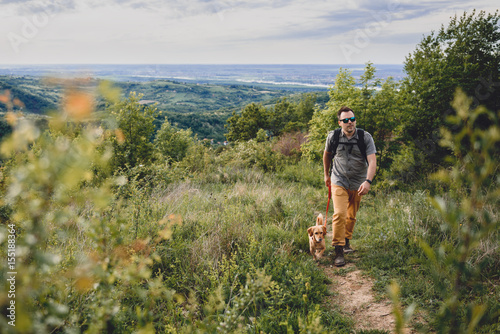 Man with a dog walking along a hiking trail