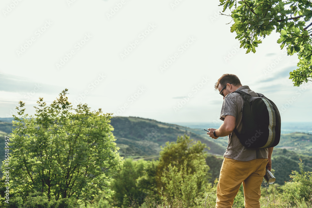 Man checking smart phone in the forest