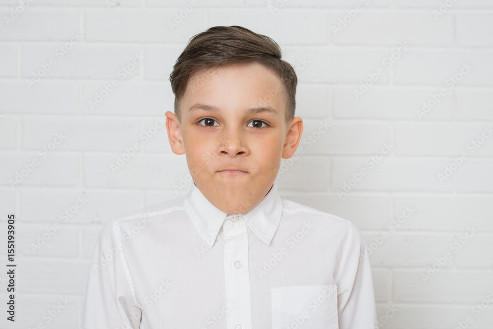 Portrait of angry boy in white shirt . Negative human emotion, facial expression. Closeup Portrait of angry boy in white shirt . Negative human emotion, facial expression. Closeup