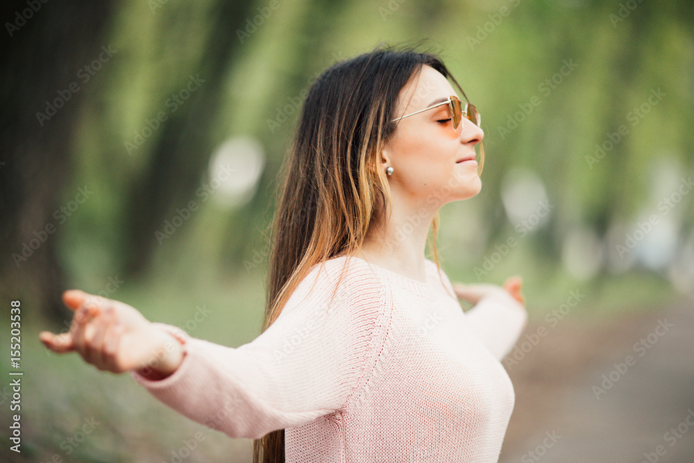 Young woman enjoying spring breeze in the green park. Young woman enjoying spring breeze in the green park.