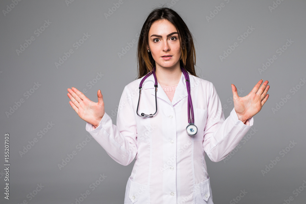 Smiling happy doctor pointing with raised hands on grey background Smiling happy doctor pointing with raised hands on grey background