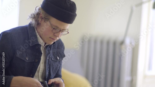 Trendy Man Loosens His Boot Laces, Sets Boot Down, Pulls Back On The Heel And Puts His Foot In 