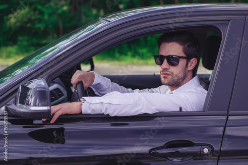 Close up of a male model in a parked car with sunglasses  © Marko
