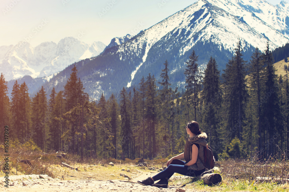 Woman sitting on natural mountain background