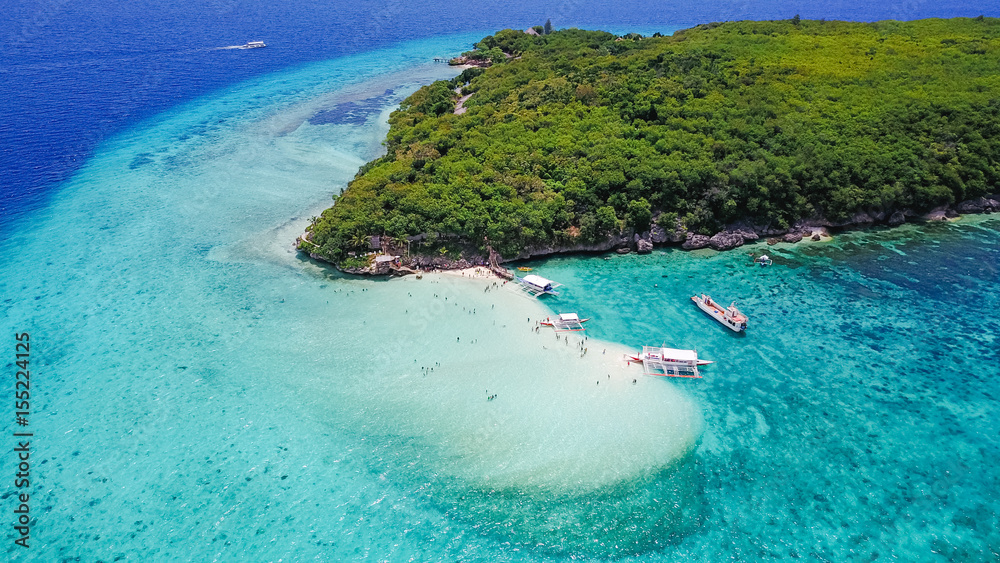 Fototapeta premium Aerial view of sandy beach with tourists swimming in beautiful clear sea water of the Sumilon island beach landing near Oslob, Cebu, Philippines. - Boost up color Processing.