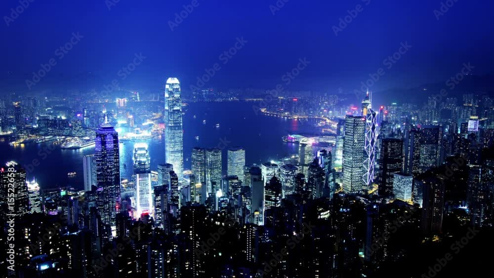 Hong Kong of China. Typical Hong Kong Establishing Shot in 4K. Zoom Out Shot. Wide and high angle view from the Peak of Hong Kong. Corporate buildings and busy traffic under clear night sky. Hong Kong of China. Typical Hong Kong Establishing Shot in 4K. Zoom Out Shot. Wide and high angle view from the Peak of Hong Kong. Corporate buildings and busy traffic under clear night sky.