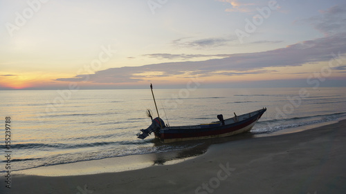 fishing boats on the beach at sunrise