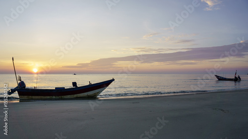fishing boats on the beach at sunrise