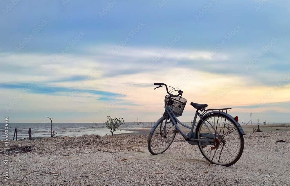 a bicycle at the beach with blue sky as background