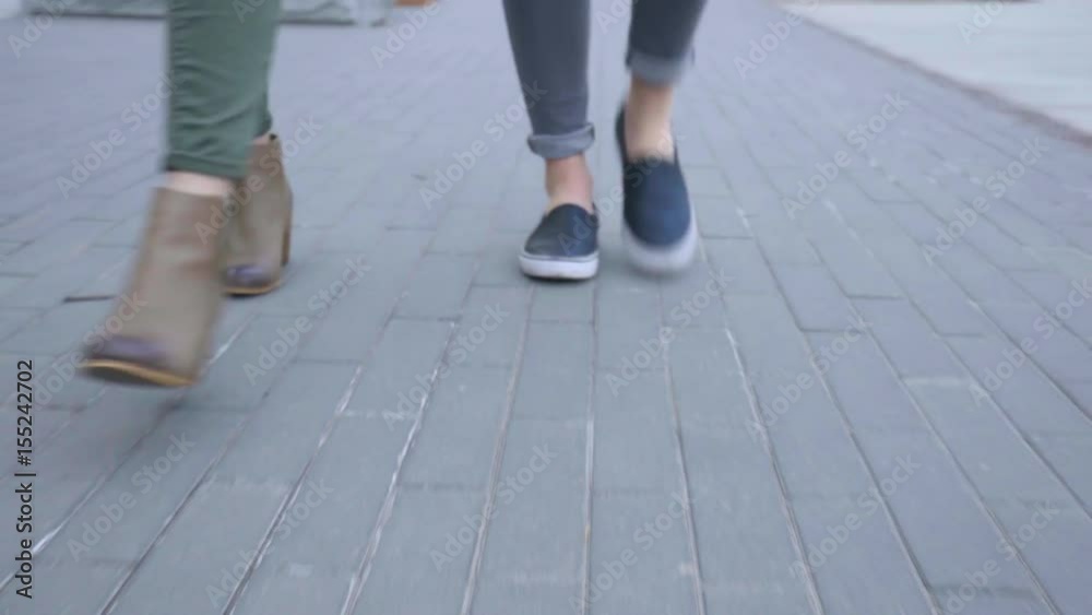 Closeup Of Teens Feet As They Walk Down Brick Path In City