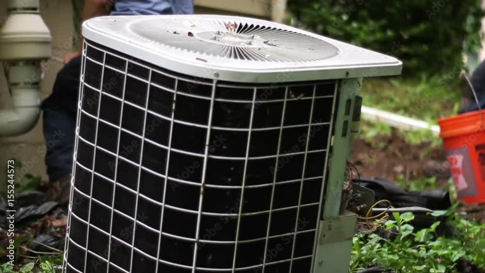 A pair of HVAC Technicians prepare to remove an old air conditioner unit