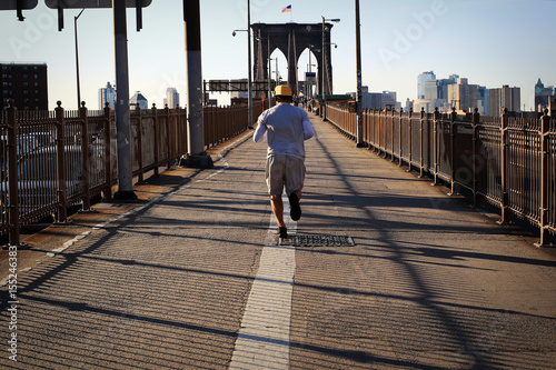 Morning jog across the bridge on the background of New York © Zarya Maxim