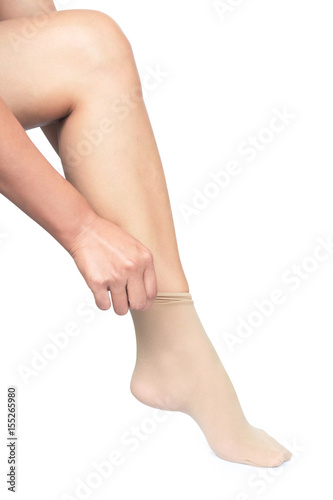 Woman hand wearing nylon stockings on her legs with white background