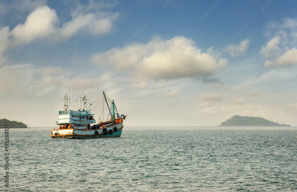 Wooden fishing boat on the beach/Fishing boat on the beach blue sky background in Thailand/The fishing boat at sandy beach/Tropical beach Andaman sea Thailand wooden fishing boat on sea in morning 