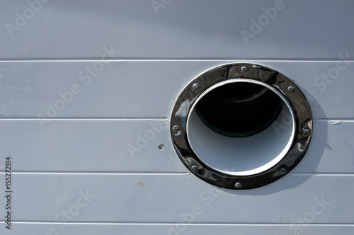 Porthole on side of yacht with chip in gelcoat