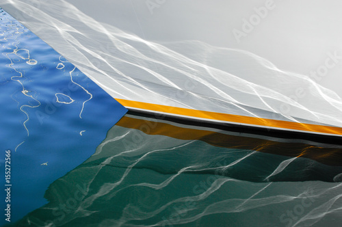 Light being reflected from the surface of the water is also reflected into the hull of large yacht