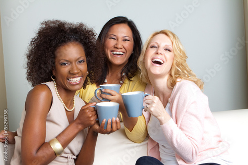 Diverse group of women talking and drinking coffee.