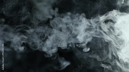 Vapor like smoke on a dark black background. Vape smoke rings in motion at vape clouds.