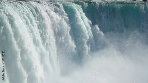 SLOW MOTION, CLOSE UP: Powerful raging whitewater waterfall falling forcefully over a rocky edge. Crystal clear glacier water stream dropping over the cliff. Misty majestic Niagara Falls river rapids photo