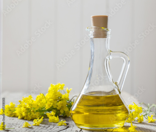 rapeseed oil  canola  and rape flowers on wooden table