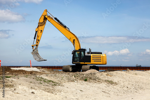Excavator works on a construction site with excavation
