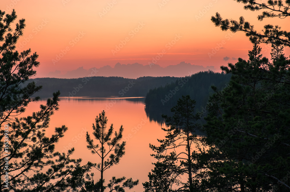 Naklejka premium Scenic landscape with sunset and lake at summer night in Finland