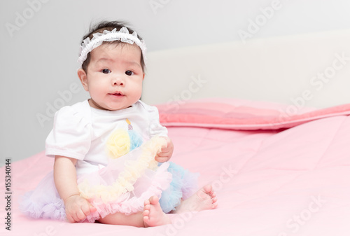 pretty girl baby sit on pink blanket