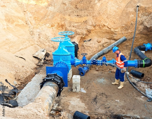 Worker underground on gate valve, reconstrucion of drink water system photo