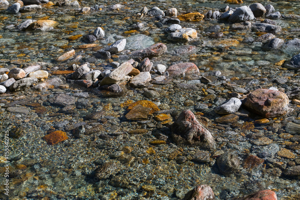 crystal clear water and colorful stones of wild river verzasca in switzerland
