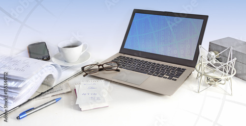 business office workspace, laptop, cell phone, glasses and papers on a white desktop, bright blue background with matrix, panoramic banner for website header, copy space
