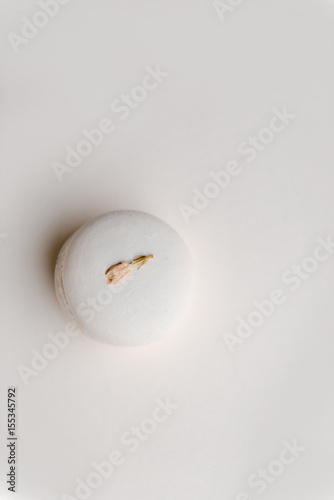 One sweet white macaroon on white table background.