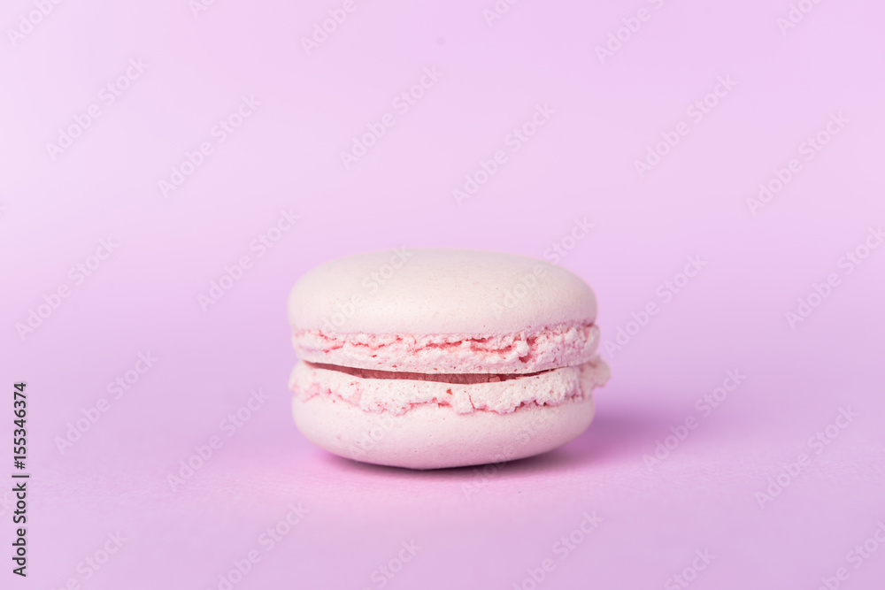 One sweet purple macaroon on purple table background. One sweet purple macaroon on purple table background.
