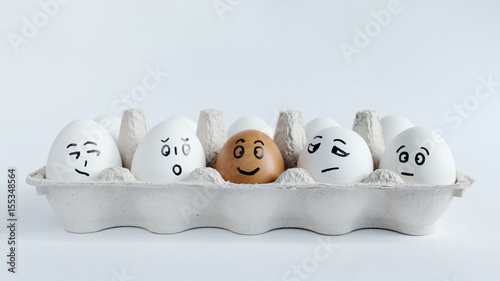 Eggs with funny faces in the package on a white background. Easter Concept Photo. Faces on the eggs