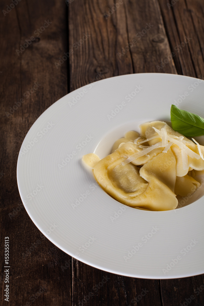 Plate of big tortellini in a wooden table Plate of big tortellini in a wooden table