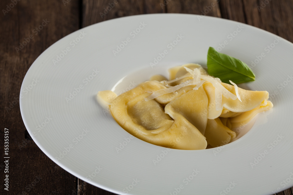 Plate of big tortellini in a wooden table