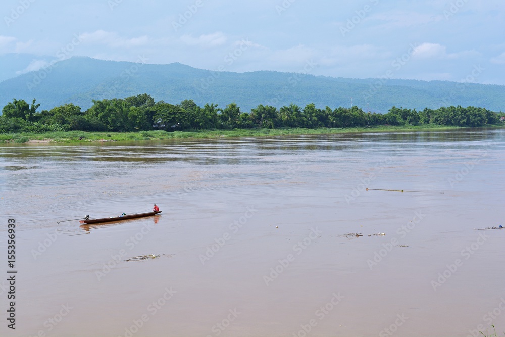 Fishermen fish in the Mekong  River There is a high mountain backdrop.