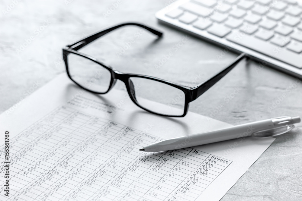accounting work space with glasses, profit and tables on stone desk close up accounting work space with glasses, profit and tables on stone desk close up