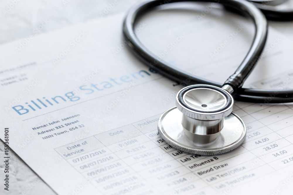 health care billing statement with doctor's stethoscope on stone background health care billing statement with doctor's stethoscope on stone background