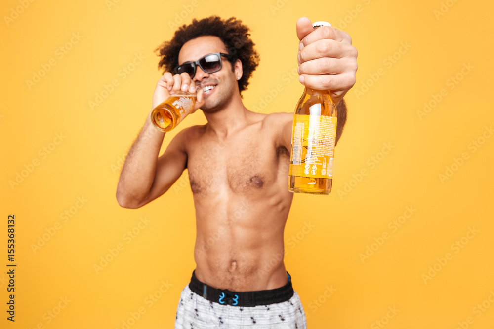 Portrait of a african man in sunglasses showing beer bottle Portrait of a african man in sunglasses showing beer bottle