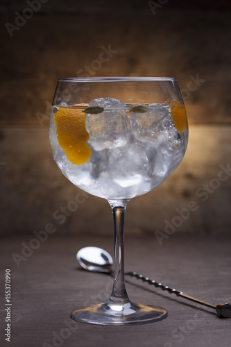 Gin and tonic cocktail on a wooden table with background