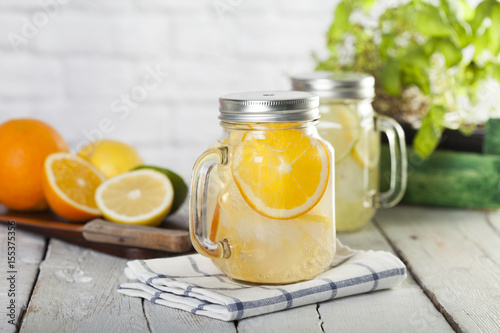Lemonade in a mason jar with fruit slices on a wooden table