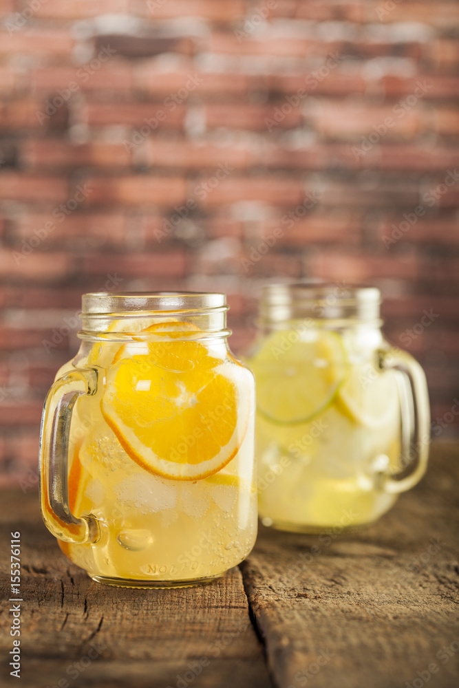 Lemonade in a mason jar with fruit slices on a wooden table Lemonade in a mason jar with fruit slices on a wooden table