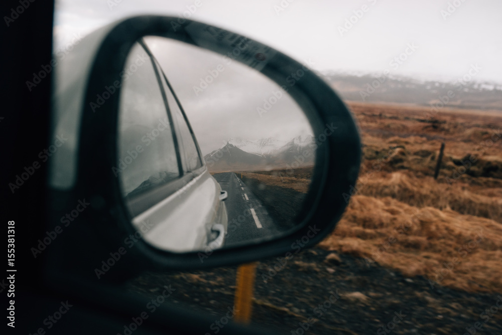 Reflection of mountains in the mirror of a moving car