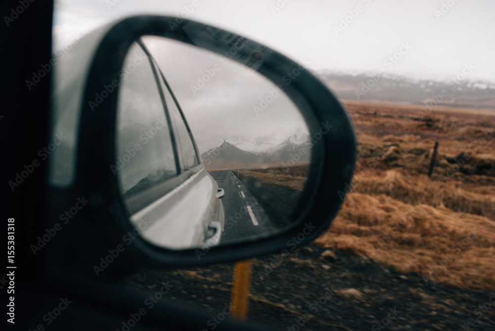 Reflection of mountains in the mirror of a moving car Reflection of mountains in the mirror of a moving car
